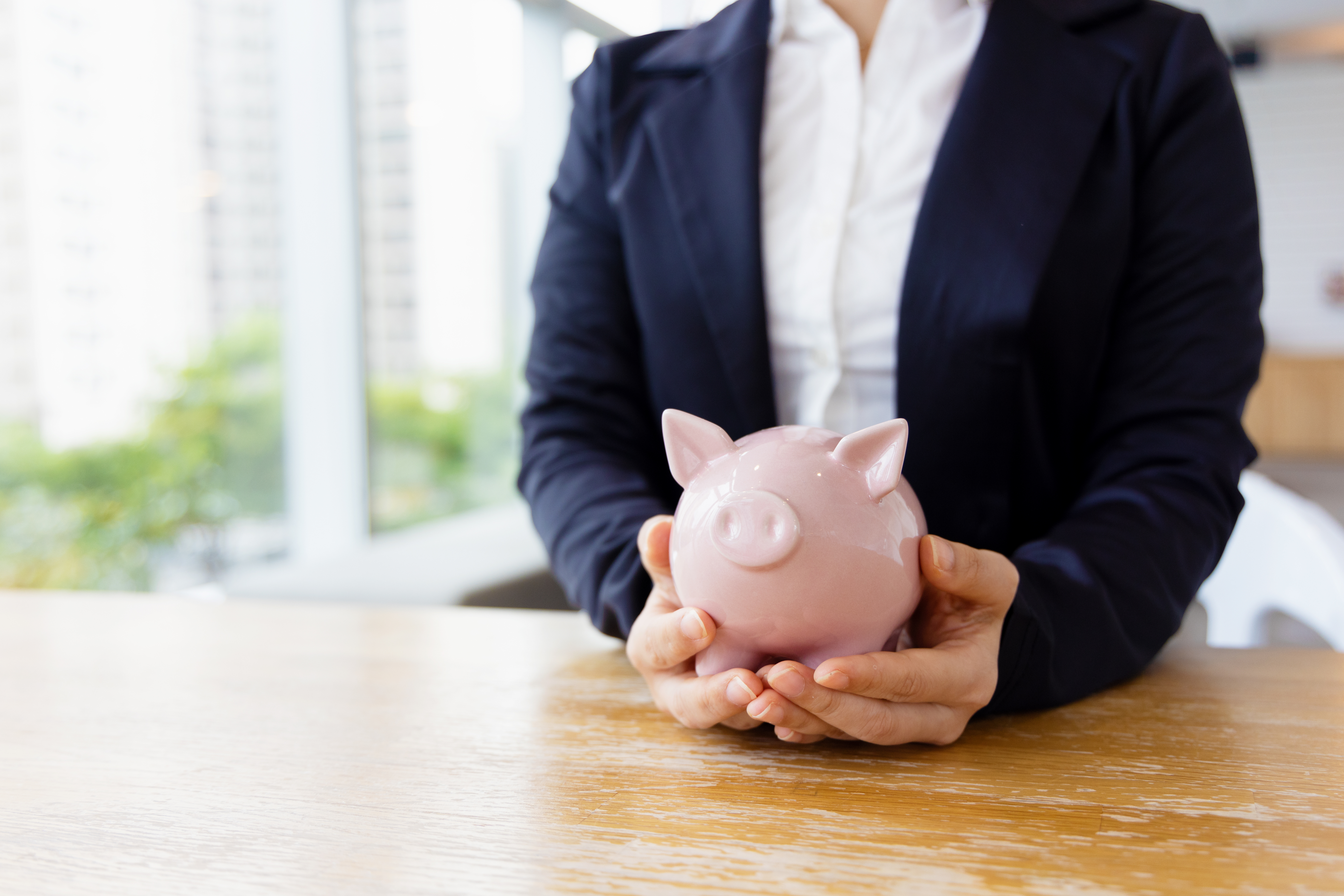 Woman putting coin in piggy bank
